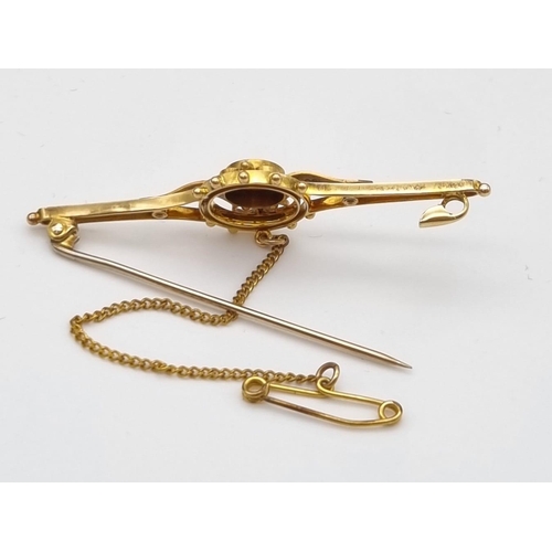 352 - AN EDWARDIAN SINGLE DIAMOND BAR BROOCH IN 15K GOLD WITH SAFETY CHAIN.  4.0gms