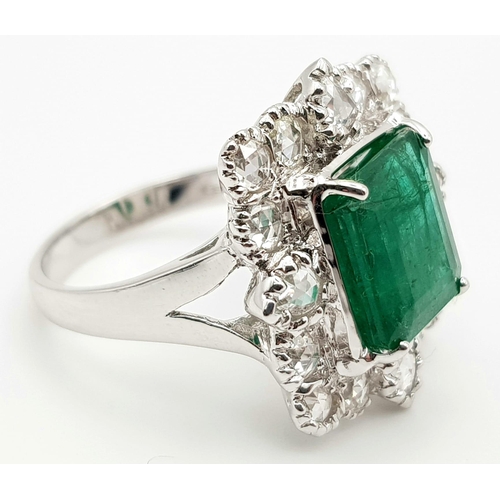 10 - A WGI Certified 18K White Gold Emerald and Diamond Ring. A 4.1ct centre cut natural emerald surround... 