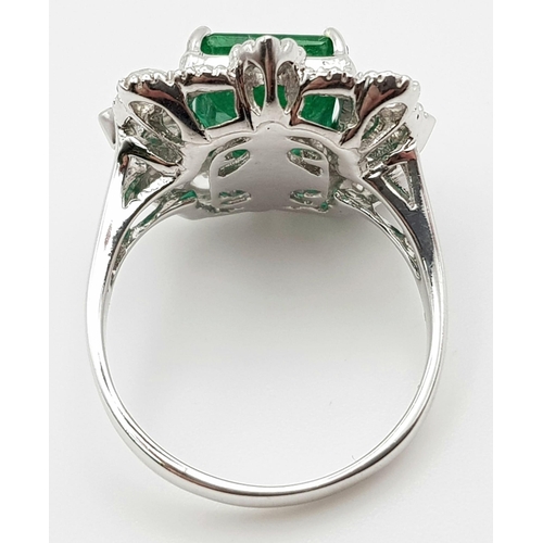 10 - A WGI Certified 18K White Gold Emerald and Diamond Ring. A 4.1ct centre cut natural emerald surround... 