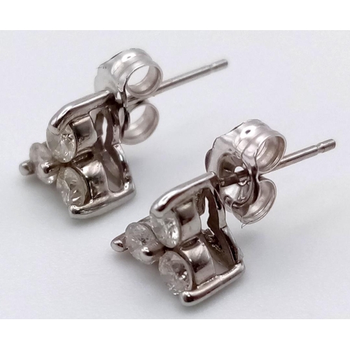 117 - A PAIR OF 14K WHITE GOLD 3 DIAMOND STUD EARRINGS .  1.3gms