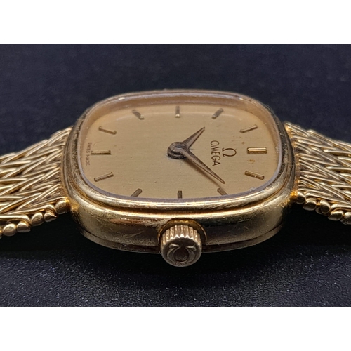 249 - An 18K Solid Gold Omega Ladies Dress watch. 18k bracelet and case - 16 x 16mm. Gold tone dial. Mecha... 