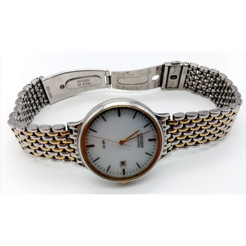 528 - A Citizen Eco Drive Watch. Two tone strap and case - 35mm. White dial with date window. In working o... 