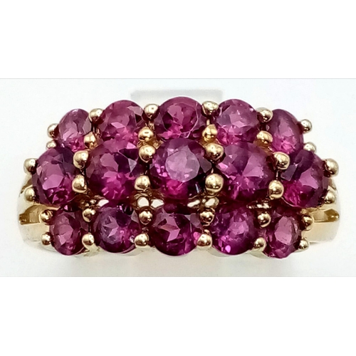 272 - A 9K Yellow Gold Three-Row Ruby Ring. Fifteen clean, quality rubies add a touch of class to this pie... 