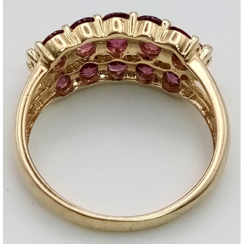 272 - A 9K Yellow Gold Three-Row Ruby Ring. Fifteen clean, quality rubies add a touch of class to this pie... 