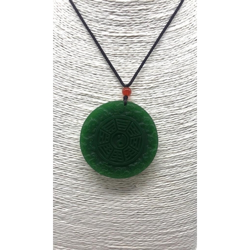 507 - A Green Jade Circular Pendant. Decorated with Chinese Lunar characters. 5cm diameter.