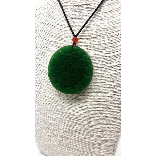 507 - A Green Jade Circular Pendant. Decorated with Chinese Lunar characters. 5cm diameter.