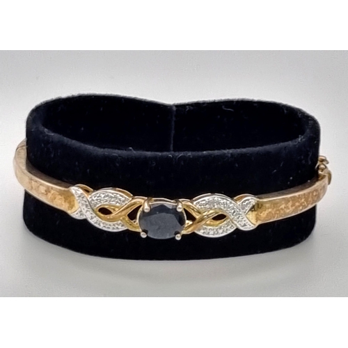 586 - STERLING SILVER WITH GOLD TONE DIAMOND AND BLUE STONE BANGLE 12.6G