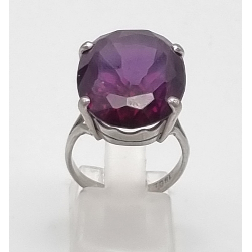 18 - An 18K White Gold Amethyst Ring. Large central clean amethyst - 20ct. Size M. 10g total weight.