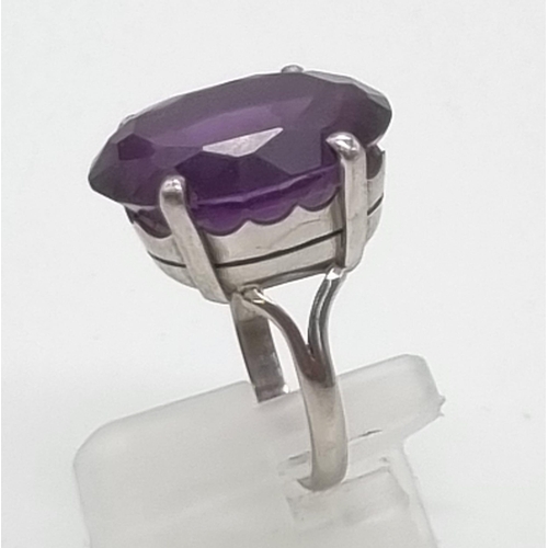 18 - An 18K White Gold Amethyst Ring. Large central clean amethyst - 20ct. Size M. 10g total weight.