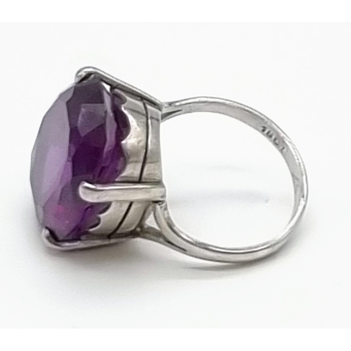 18 - An 18K White Gold Amethyst Ring. Large central clean amethyst - 20ct. Size M. 10g total weight.