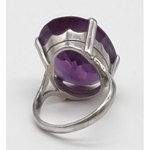 18 - An 18K White Gold Amethyst Ring. Large central clean amethyst - 20ct. Size M. 10g total weight.