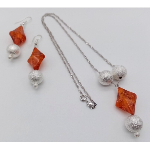 224 - A glamorous sterling silver pendant (with chain) and earrings set with amber resin. Necklace length:... 