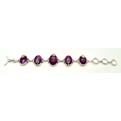 182 - A sterling silver bracelet with magenta coloured banded agate cabochons. In a presentation box. Leng... 