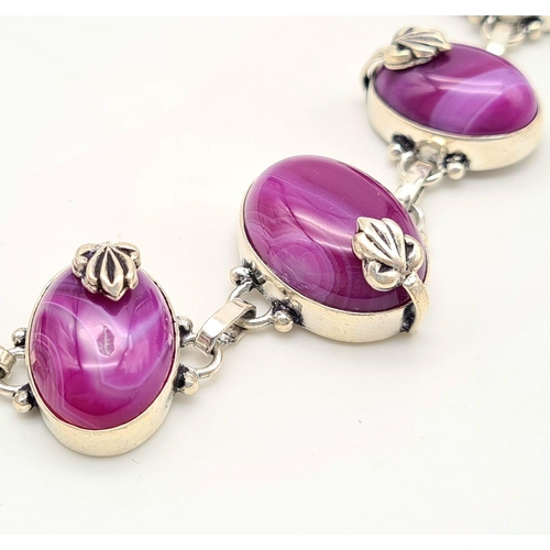 182 - A sterling silver bracelet with magenta coloured banded agate cabochons. In a presentation box. Leng... 