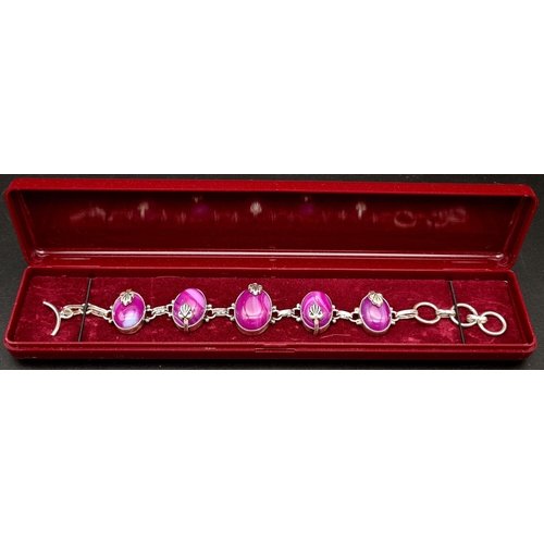 182 - A sterling silver bracelet with magenta coloured banded agate cabochons. In a presentation box. Leng... 