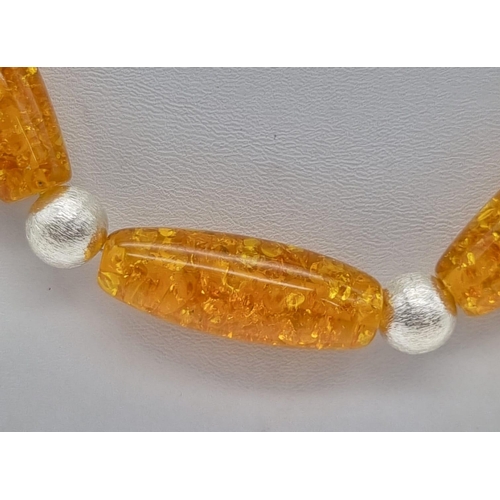 210 - A substantial amber resin necklace and earrings set with large (40 mm) beads and Tibetan silver spac... 