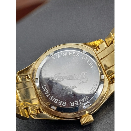 70 - A Gem Encrusted Ingersoll Quartz Watch. Gold plated strap and case - 40mm. Red and white gemstone en... 