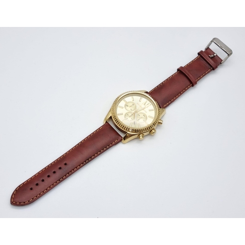 195 - A Michael Kors Chronograph Gents Watch. Brown leather strap. Gilded case - 45mm. Champagne dial with... 