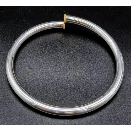 910 - A thin sterling silver and 19.2K (Portuguese) gold lyre bracelet. 16.6 grams. Inner diameter: 6cm