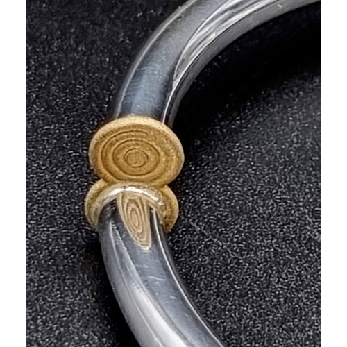 910 - A thin sterling silver and 19.2K (Portuguese) gold lyre bracelet. 16.6 grams. Inner diameter: 6cm