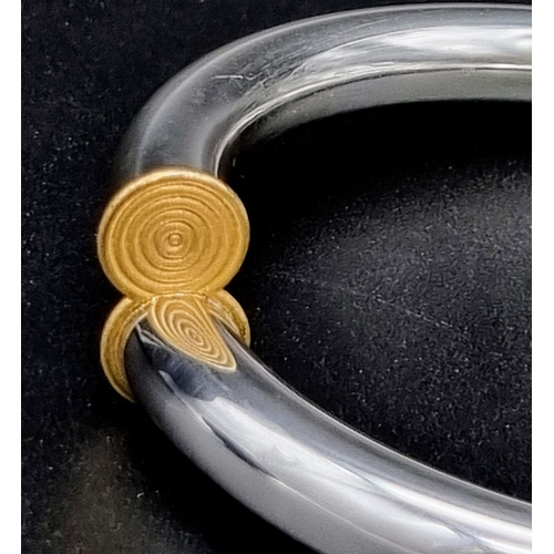 925 - A thick sterling silver and 19.2k (Portuguese) gold lyre bracelet. 29.56 grams. Inner diameter: 6cm.