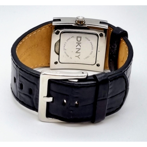 336 - A DKNY Dress Watch. Leather strap. Stainless steel case - 30 x 30mm. White stone bezel. Quartz movem... 