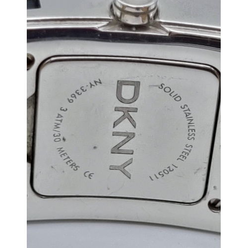 336 - A DKNY Dress Watch. Leather strap. Stainless steel case - 30 x 30mm. White stone bezel. Quartz movem... 