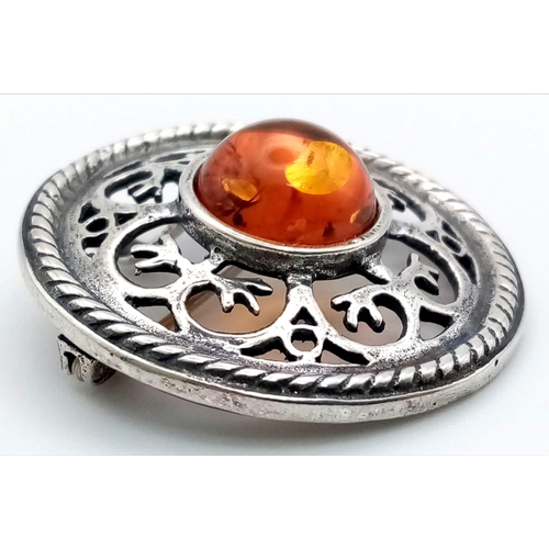 1020 - A Vintage Amber and Silver Pendant/Brooch. 4cm diameter.