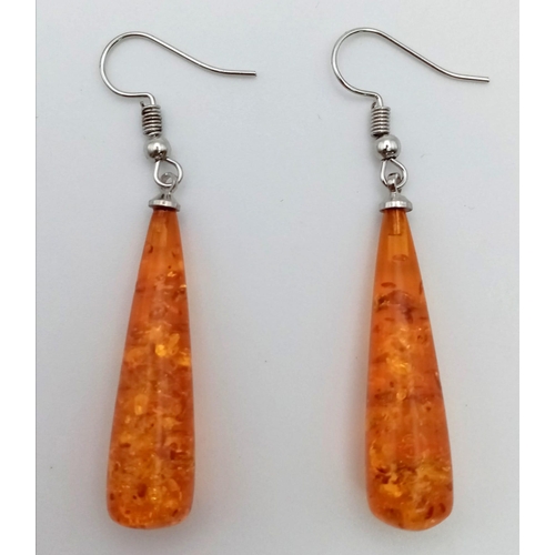 1128 - An Amber-Coloured Resin Pair of Teardrop Earrings. 4cm.