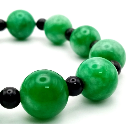 1191 - A Jade Beaded Expandable Bracelet with Garnet Spacers.