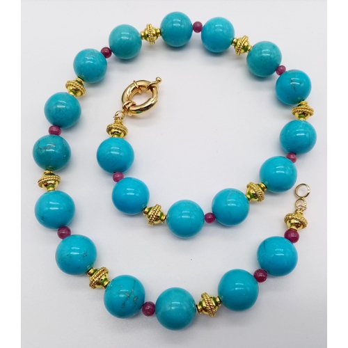 932 - A Large Turquoise Beaded and Natural Ruby Necklace. Gold plated spacers and clasp. 44cm.