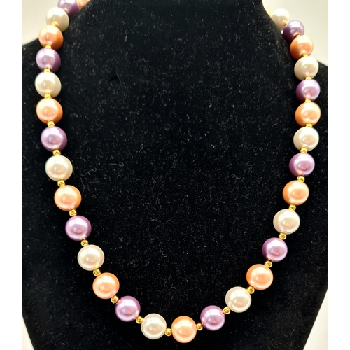 986 - A Multi-Coloured Cultured Pearl Necklace. Gilded spacers and clasp. 10mm pearls. 42cm.