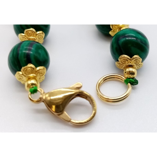 1078 - A Green Malachite Beaded Necklace. Gilded spacers and clasp. Beads - 8mm. 42cm