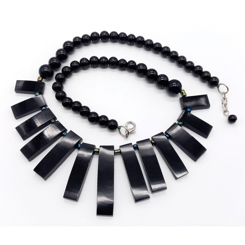 1177 - A Black Onyx Graduating Bead and Abalone Covered Tassel Necklace. 50cm