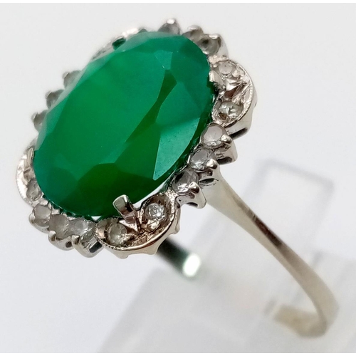 72 - An 18K White Gold Green and White Stone Ring. Size U.
3.51g total weight.