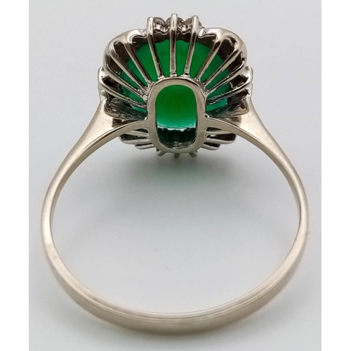 72 - An 18K White Gold Green and White Stone Ring. Size U.
3.51g total weight.