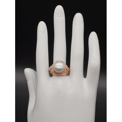 1058 - A 10ct Pearl ring in sterling silver with topaz accents in rose gold finish. ring size R