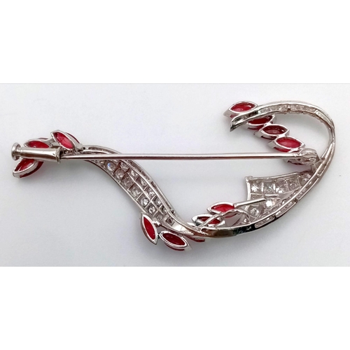 273 - A Vintage 18K White Gold Diamond and Ruby Brooch. 13 rubies on a wave of diamonds. 6 x 3cm. 7.3g tot... 