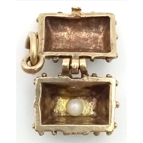 220 - A 9 K yellow gold charm of a treasure chest which opens to reveal a small pearl!. Weight: 1.8 g.