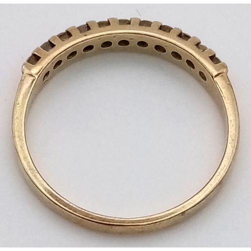 529 - A 9 K yellow gold ring with a band of eleven diamonds (0.15 carats). Ring size: M, weight: 1.6 g.