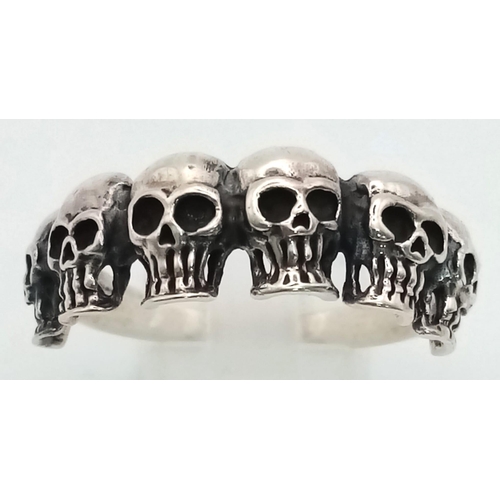 635 - A Solid Silver Six Skull Gents Ring. Z + 1. 5.7g