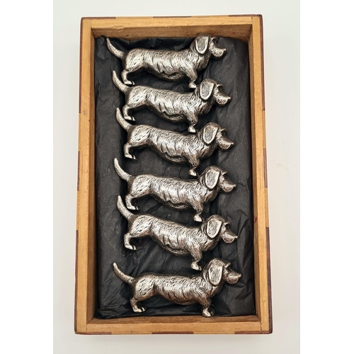 634 - Six white metal dog dachshund knife rests. Comes in a wooden oriental box. Metal dog - 49 grams each... 