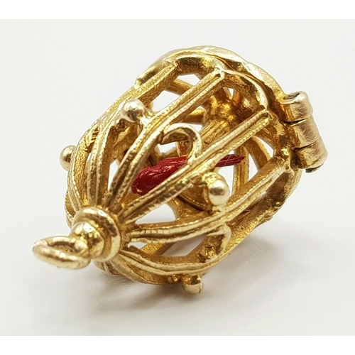 346 - A 9 K yellow gold bird cage charm, which opens to reveal a red enamelled exotic bird. Height: 20 mm,... 