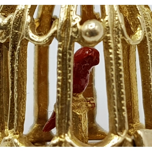 346 - A 9 K yellow gold bird cage charm, which opens to reveal a red enamelled exotic bird. Height: 20 mm,... 