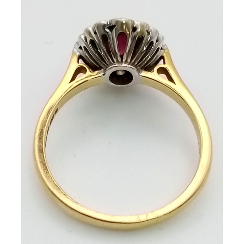 5 - An 18 K yellow gold ring with an oval cut ruby surrounded by diamonds. Ring size: R, weight: 5.4 g.