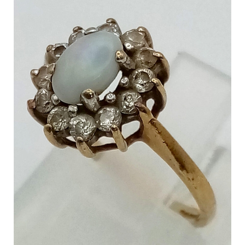 73 - A 9 K yellow gold ring with an opal cabochon surrounded by white sapphires. Ring size: I, weight: 1.... 