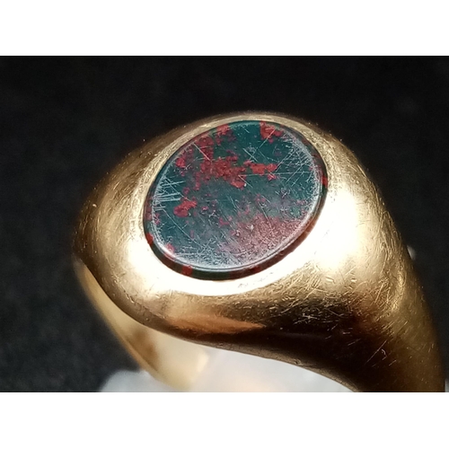 453 - A 9 K yellow gold signet ring with a blood stone cabochon. Ring size: J, weight: 4.3 g.