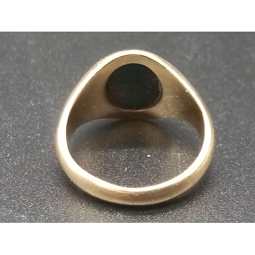 453 - A 9 K yellow gold signet ring with a blood stone cabochon. Ring size: J, weight: 4.3 g.