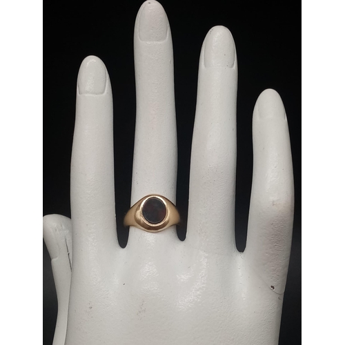 453 - A 9 K yellow gold signet ring with a blood stone cabochon. Ring size: J, weight: 4.3 g.