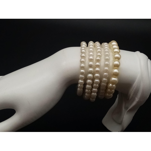 527 - A faux pearl necklace (length: 39-48 mm) AND eight expandable faux pearl bracelets.